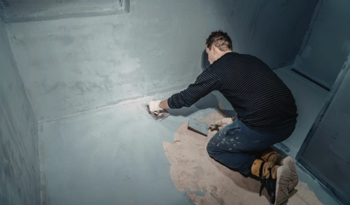 Carpenter coating a garage floor